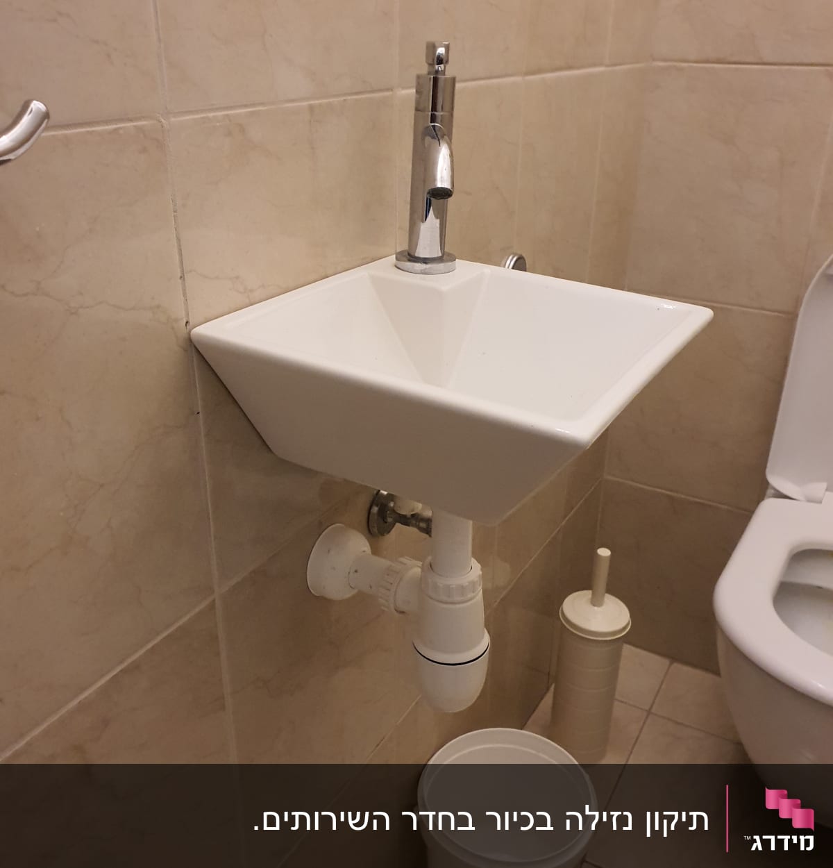 כיור עם ברז, צינור ניקוז ודלי מתחת